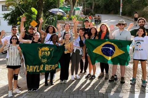 A group of student participating in Baylor in Brazil hold up Baylor and Brazil flags.